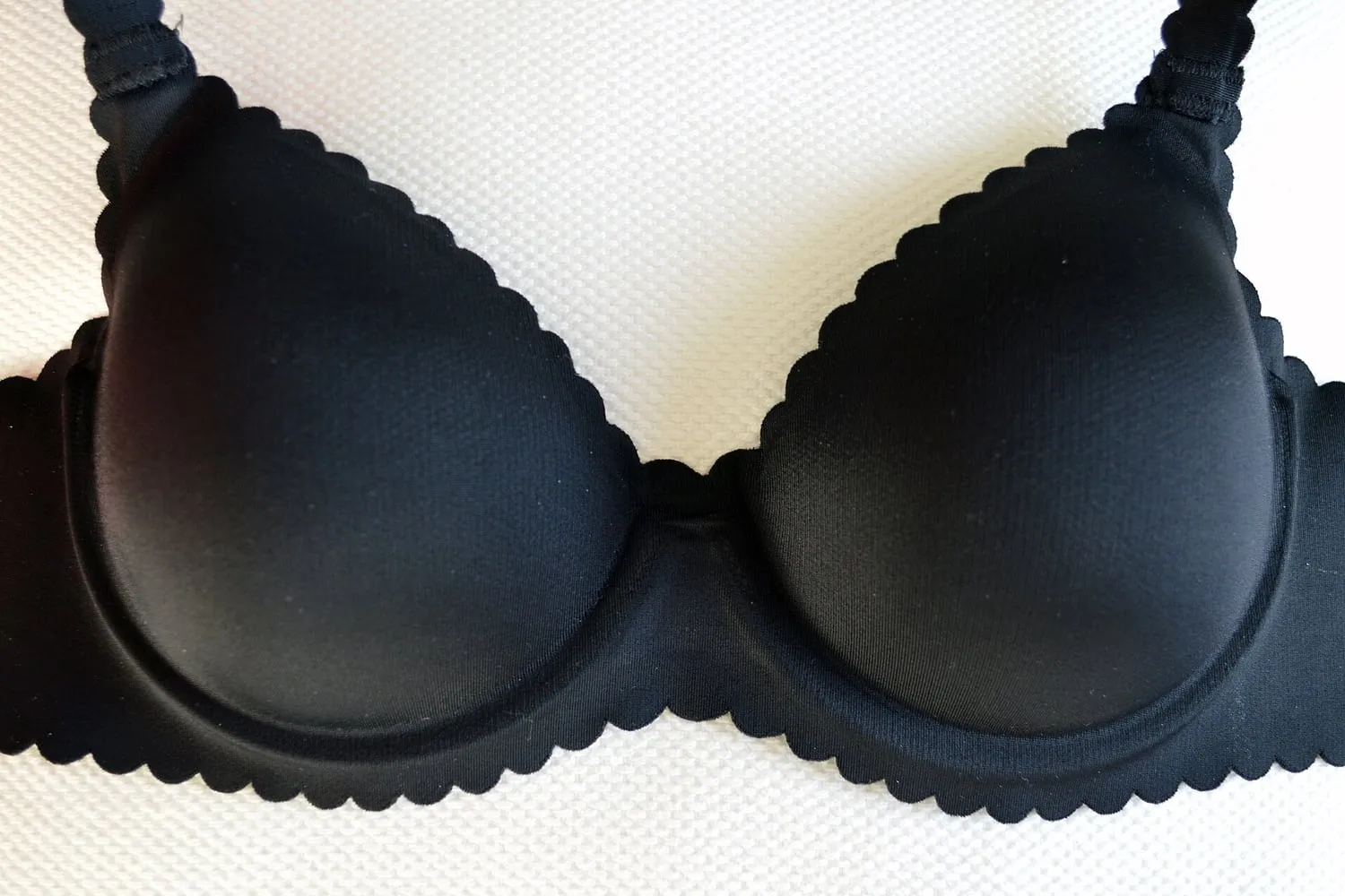 A seamless black T-shirt bra photographed as a flat lay