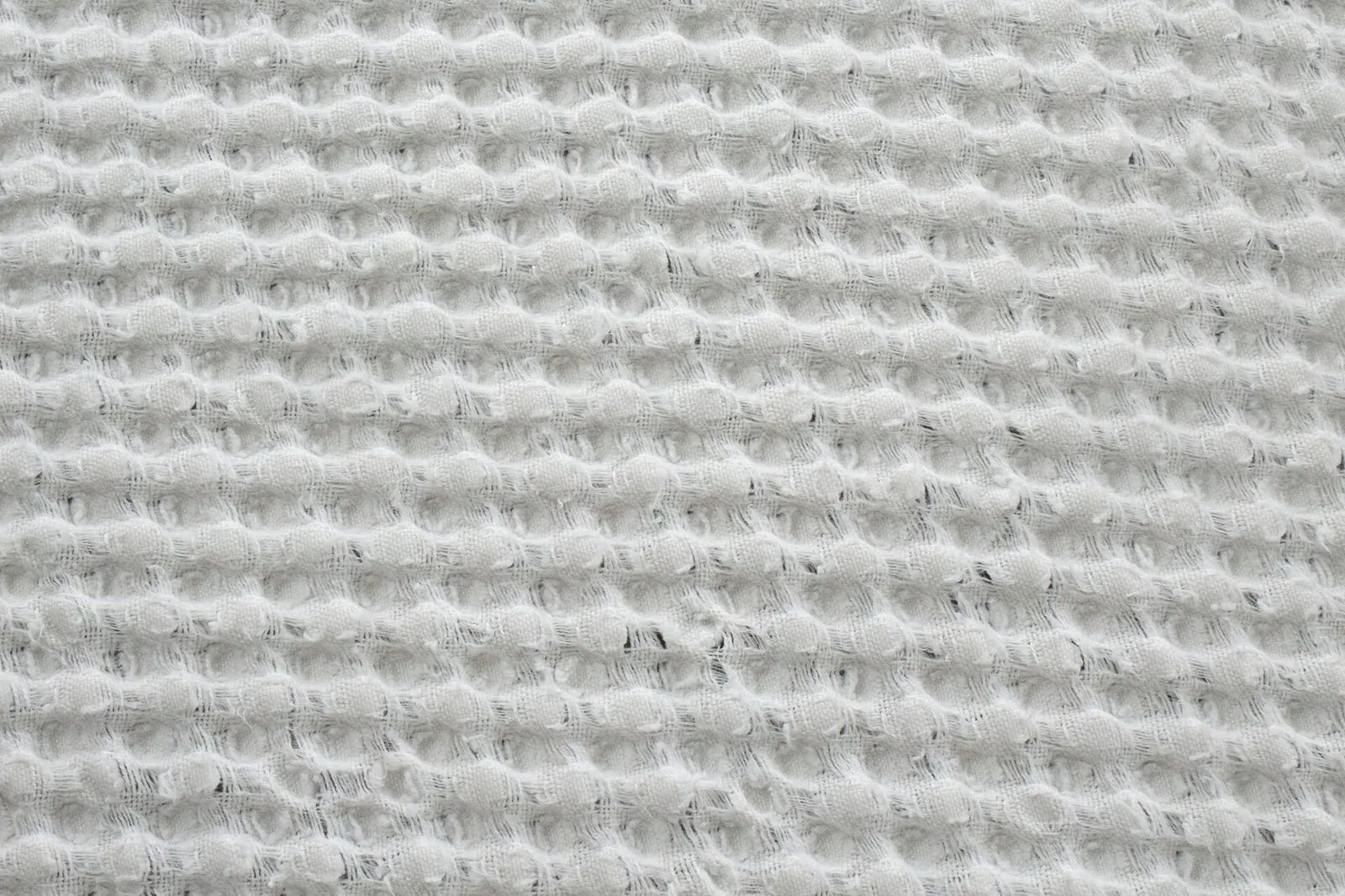 A close-up of a waffle-weave fabric showing its textured surface