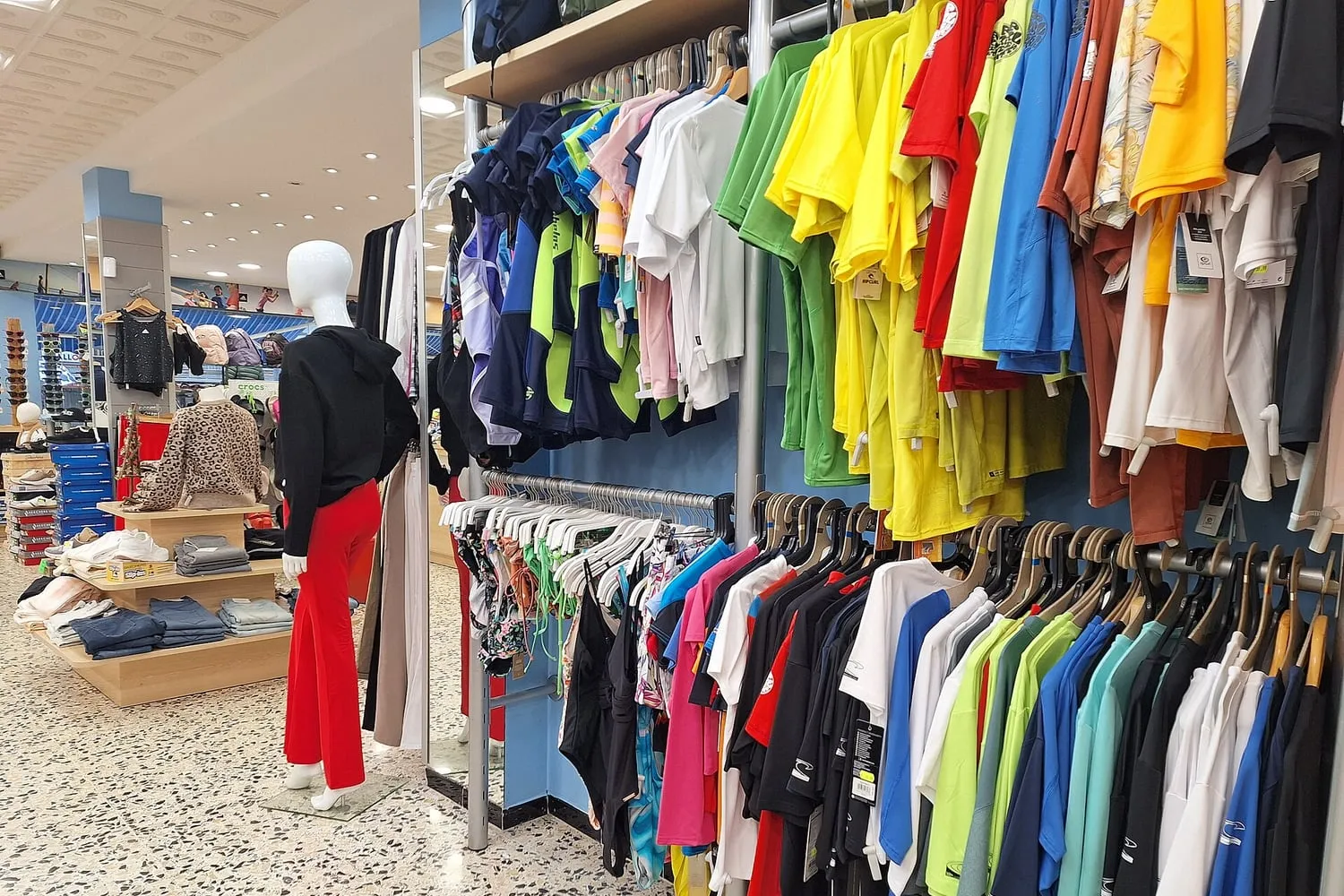Garments on hangers in a shop, photographed from a distance