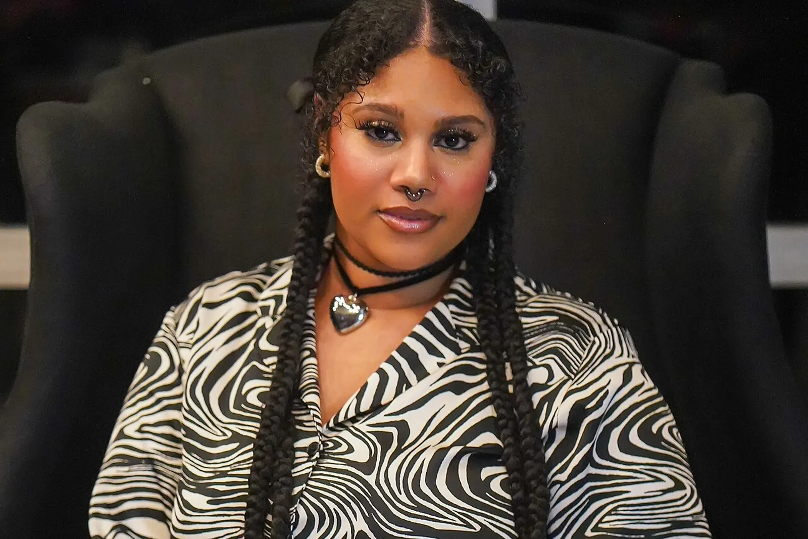 A plus-size model in a black and white graphic print blouse and dark skirt