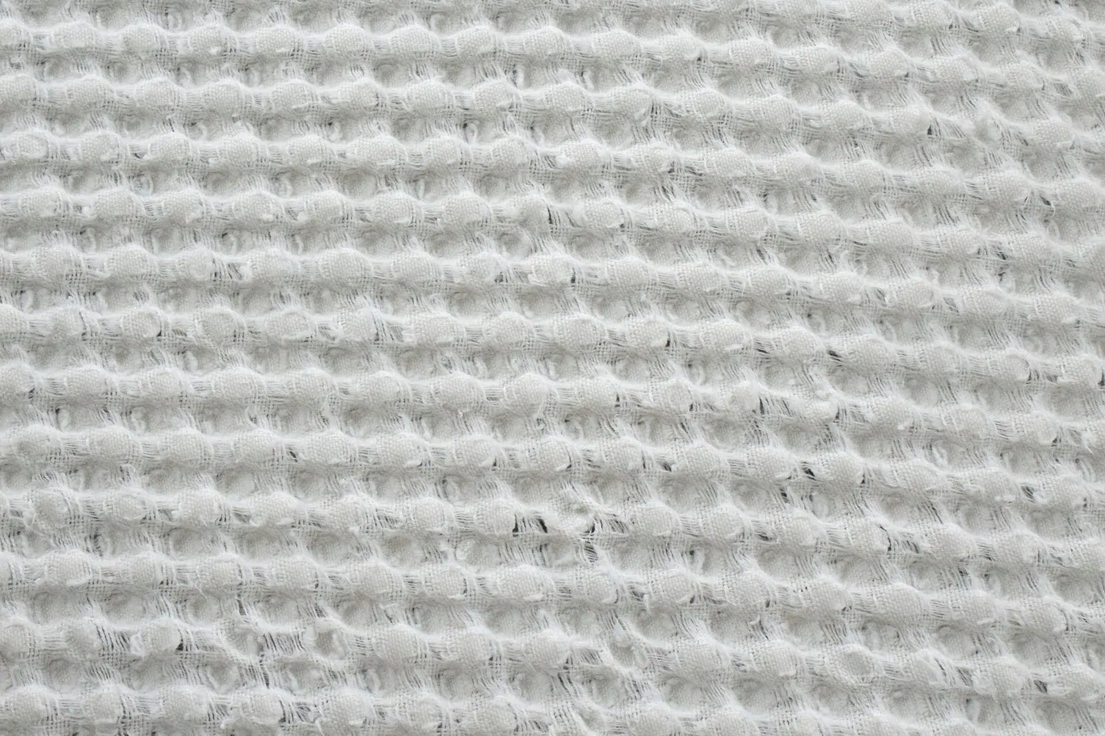 A close-up of a waffle-weave fabric showing its textured surface